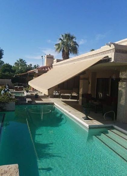 A house with a swimming pool and an awning over it