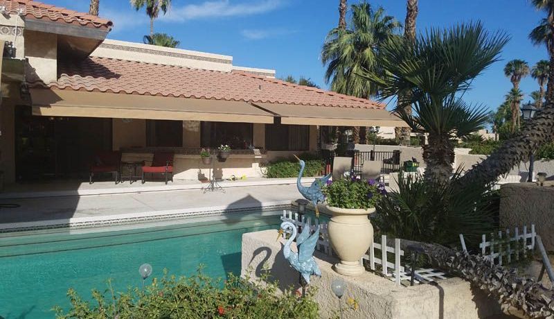 A house with a swimming pool in front of it