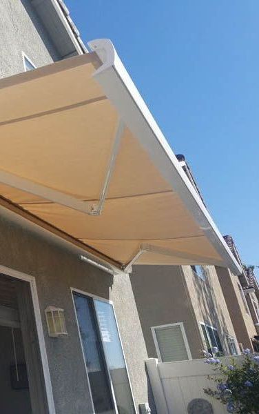 A white awning is sitting on the side of a house.