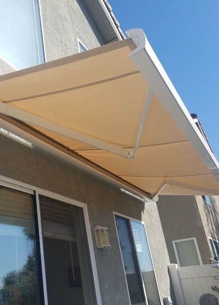 A large house with a striped awning over the front door.
