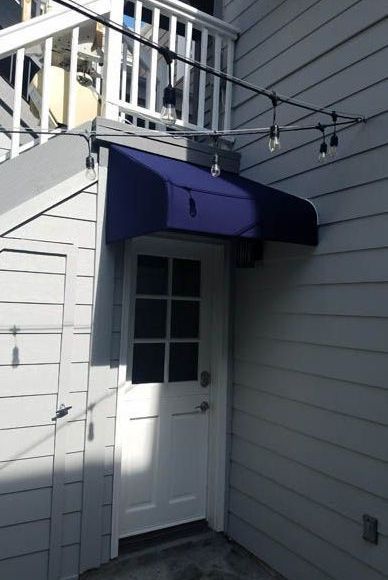 A white door with a blue awning over it