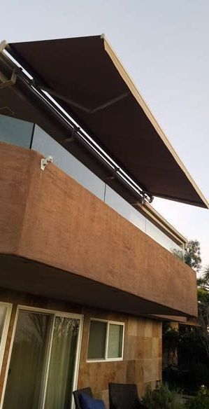 A house with a balcony with an awning on it