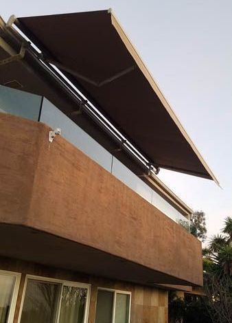 A brown awning is hanging from the side of a building.
