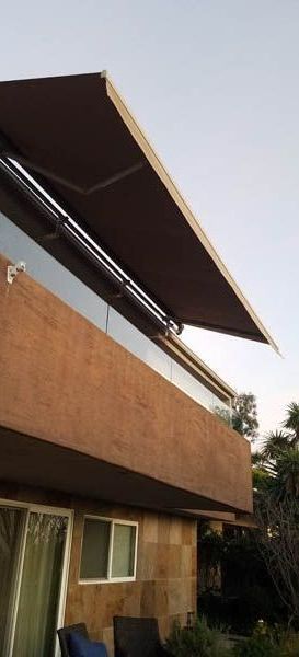 A house with a balcony and an awning on it.