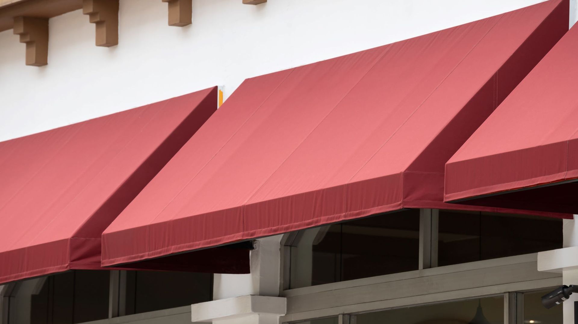 A red awning is on the side of a building.