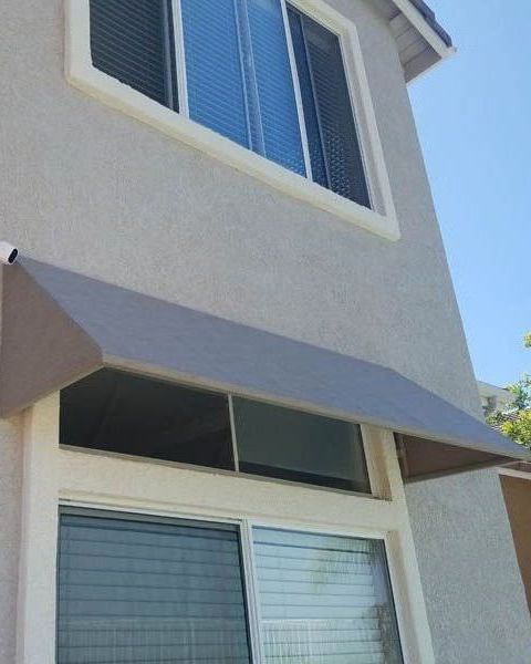 A house with a gray awning over a window