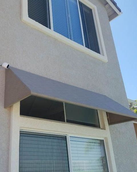 A house with a gray awning over a window
