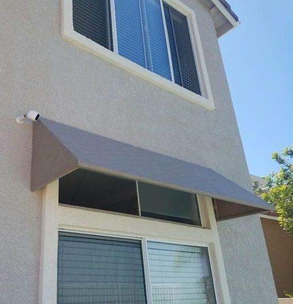 A house with a gray awning over a window