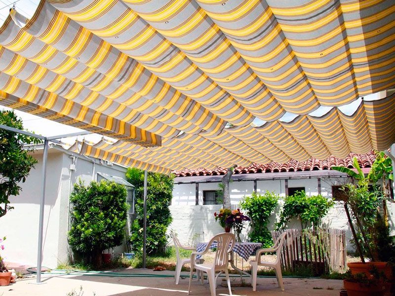 A patio with a table and chairs under an awning