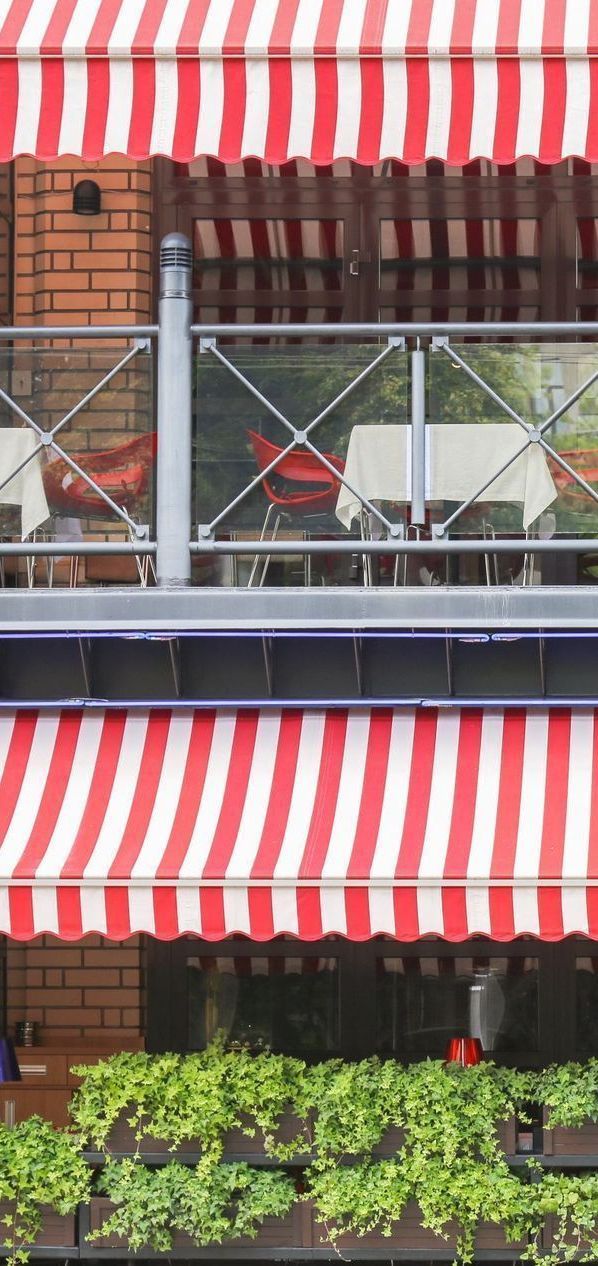 A red and white striped awning is on the side of a building.