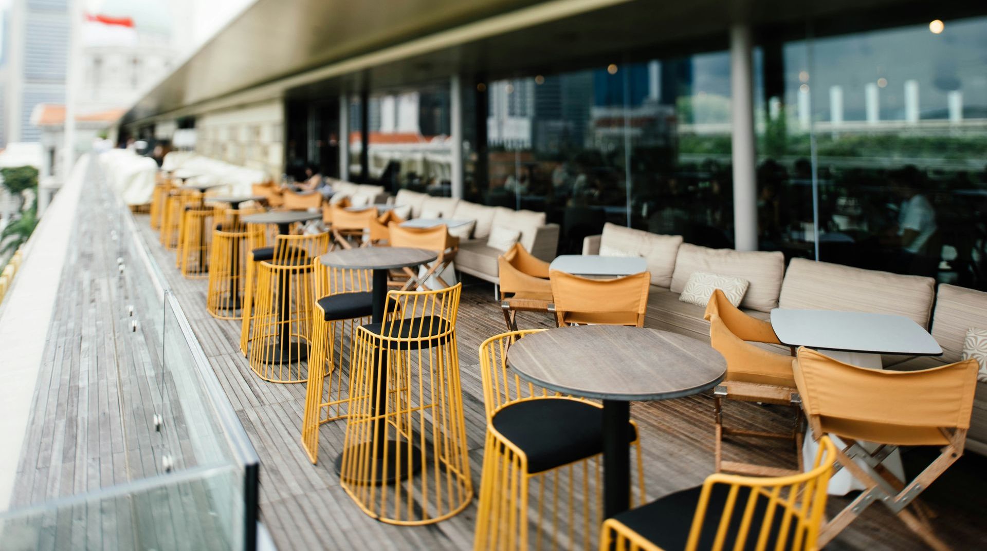 A row of tables and chairs on a wooden deck.