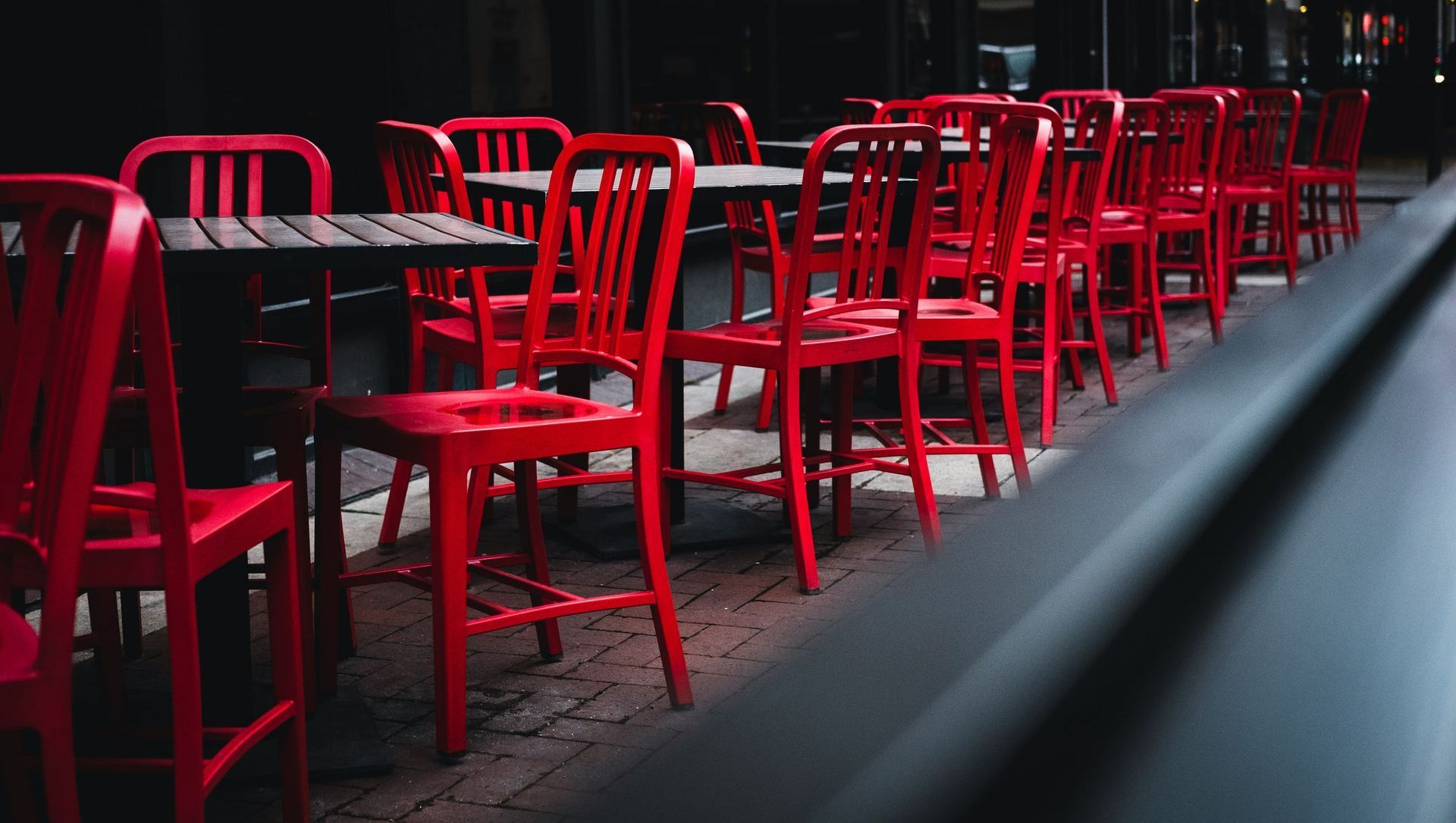 A row of red chairs and tables in a dark room.