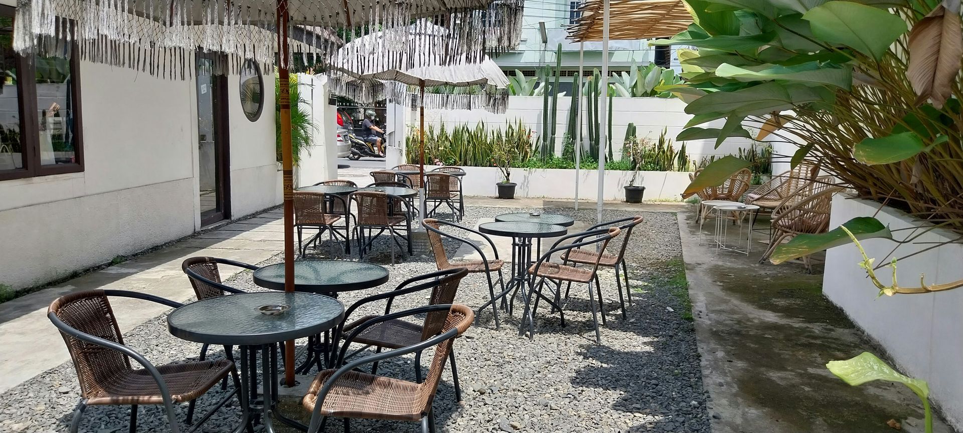 A patio with tables and chairs under umbrellas.