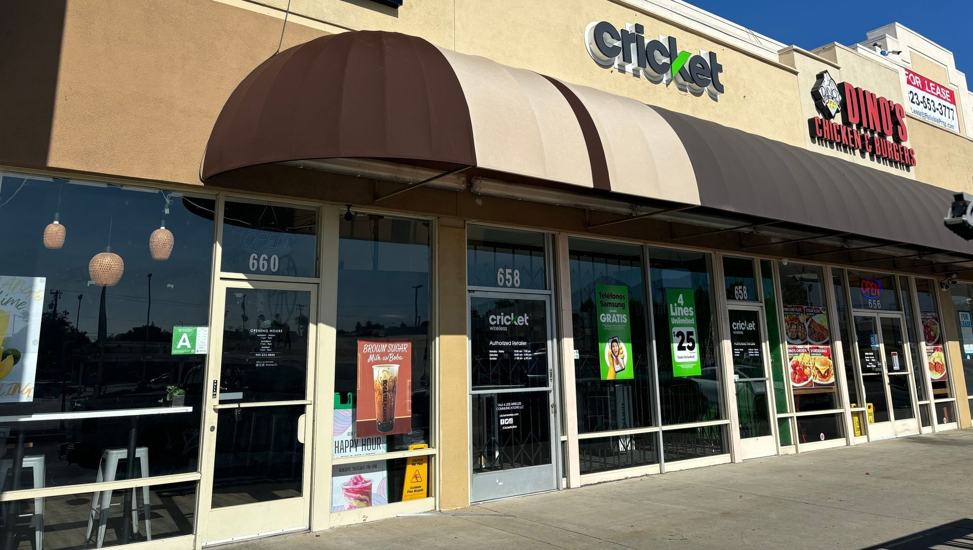 Exterior of a strip mall with Cricket and Wave Wings storefronts under a brown awning.