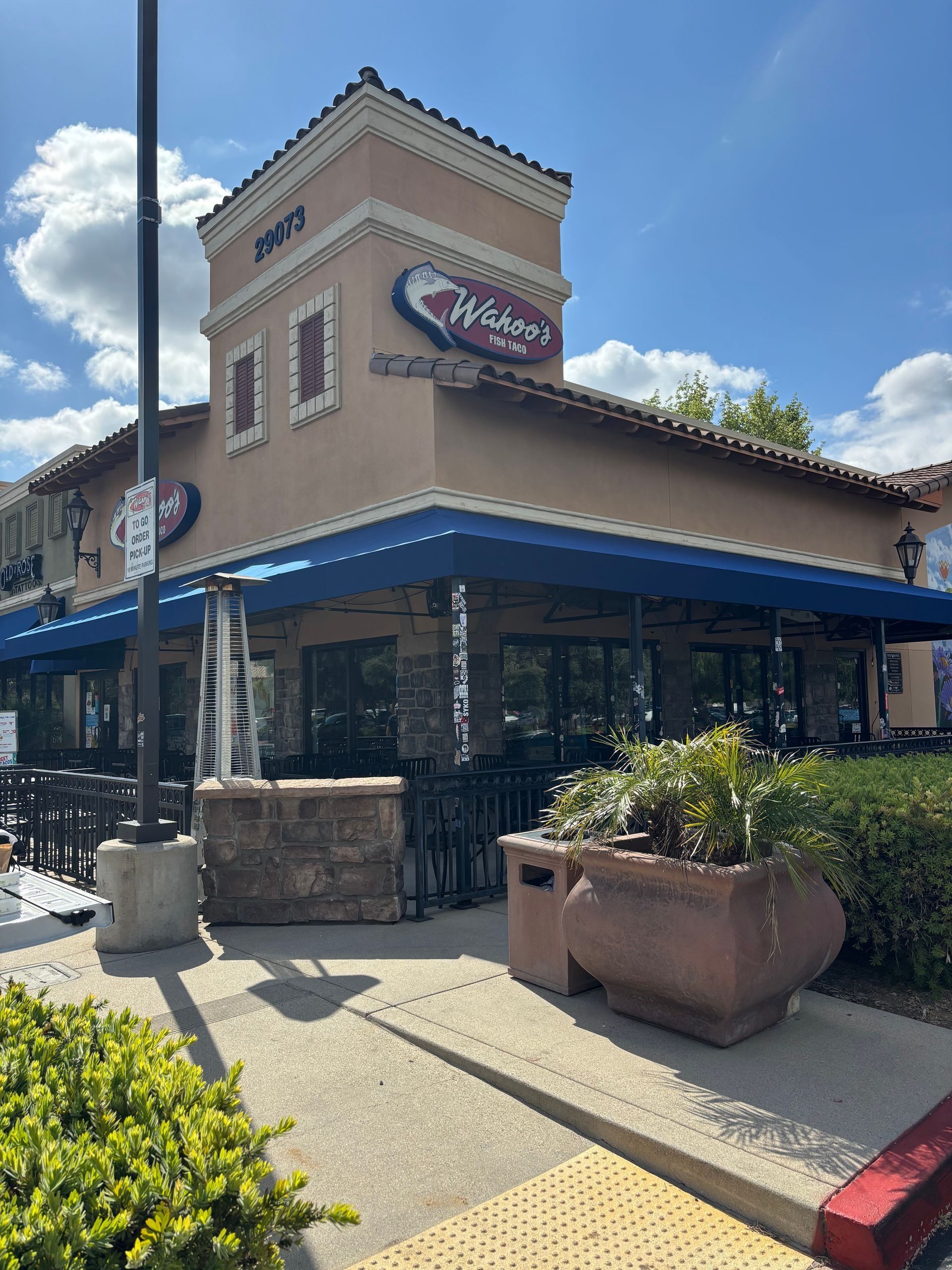 Exterior of a restaurant with blue awnings, a beige facade, and a sign that reads 