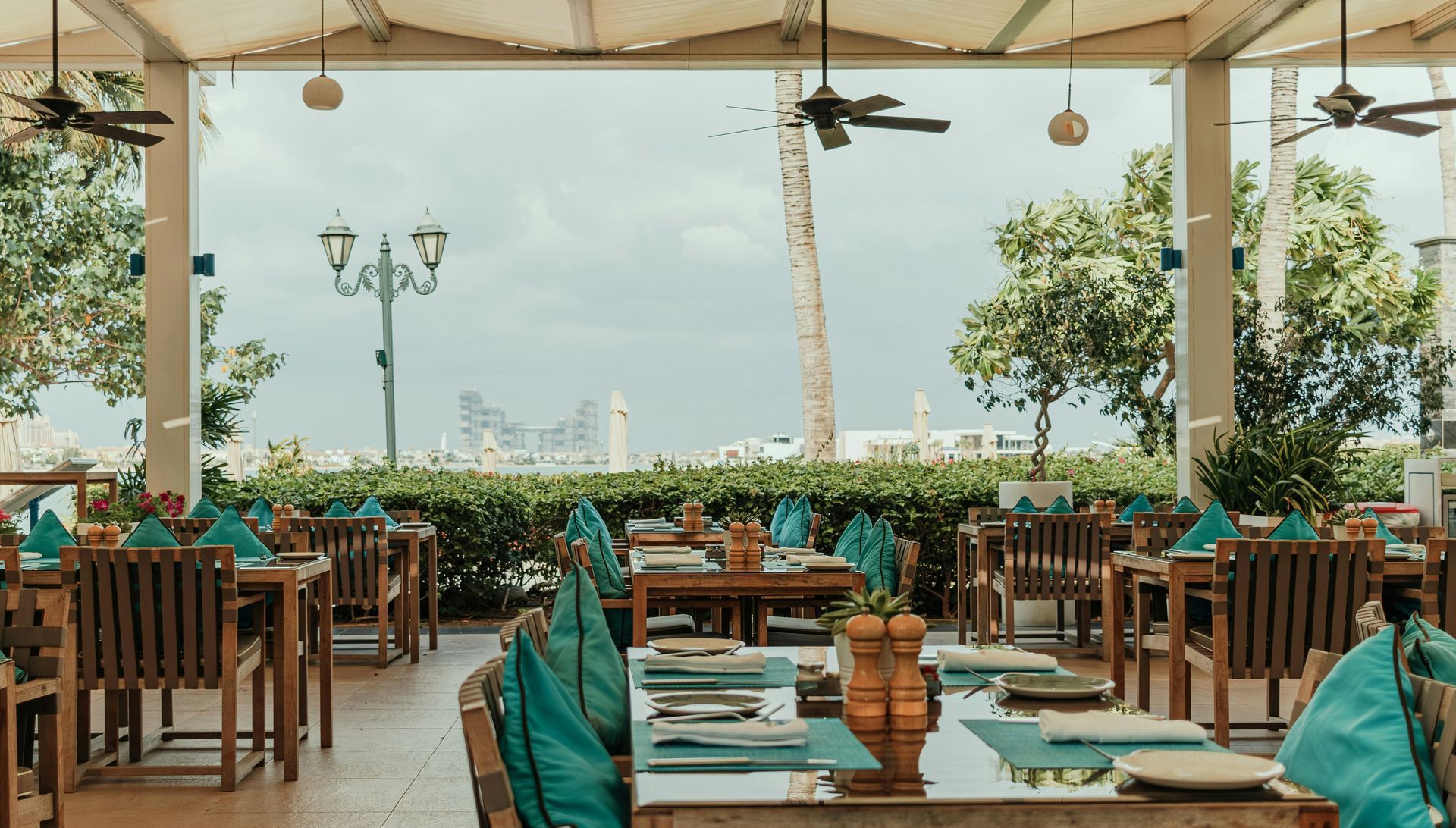 A restaurant with tables and chairs set up and a view of the ocean.