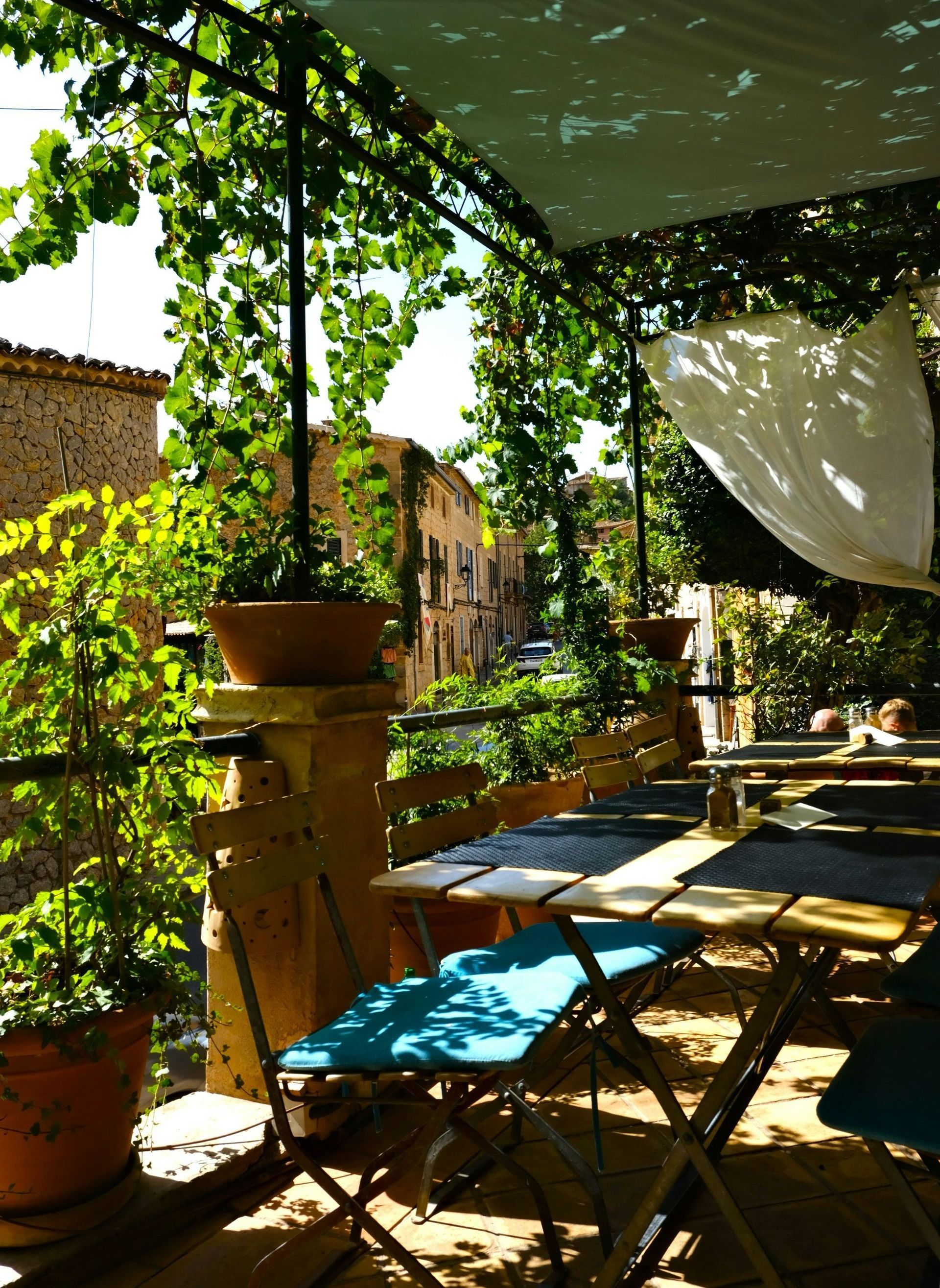 A balcony with tables and chairs under a canopy