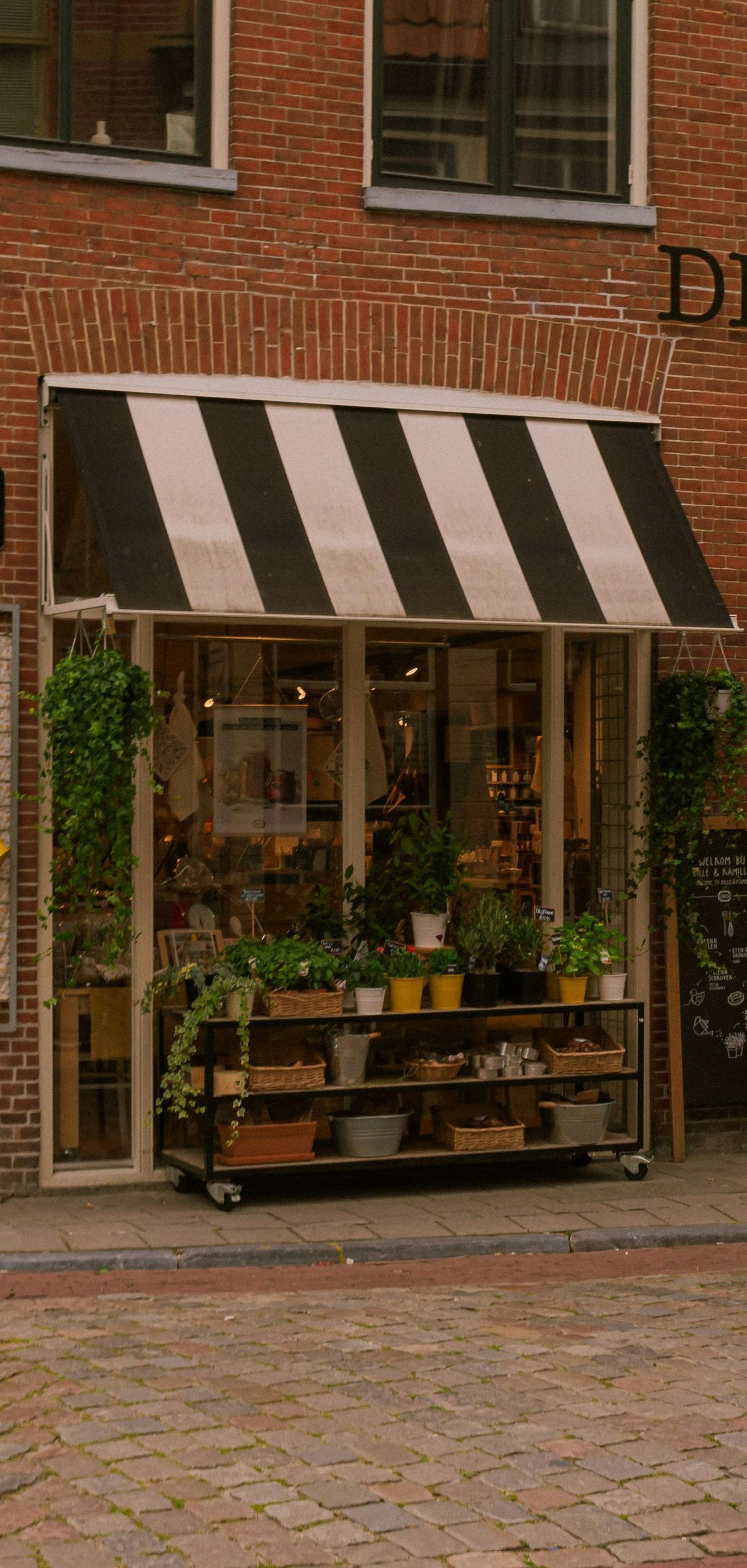A store front with a black and white awning over it.