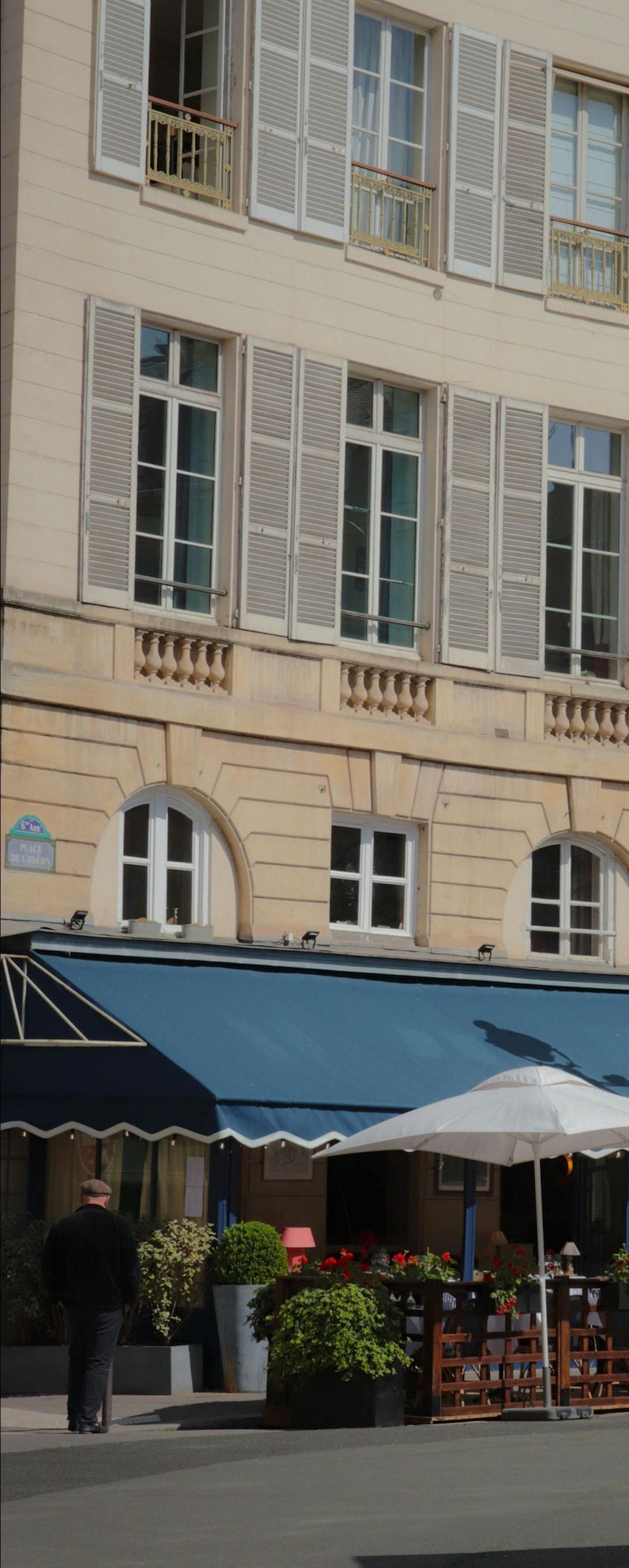 A building with blue awnings and white shutters on the windows