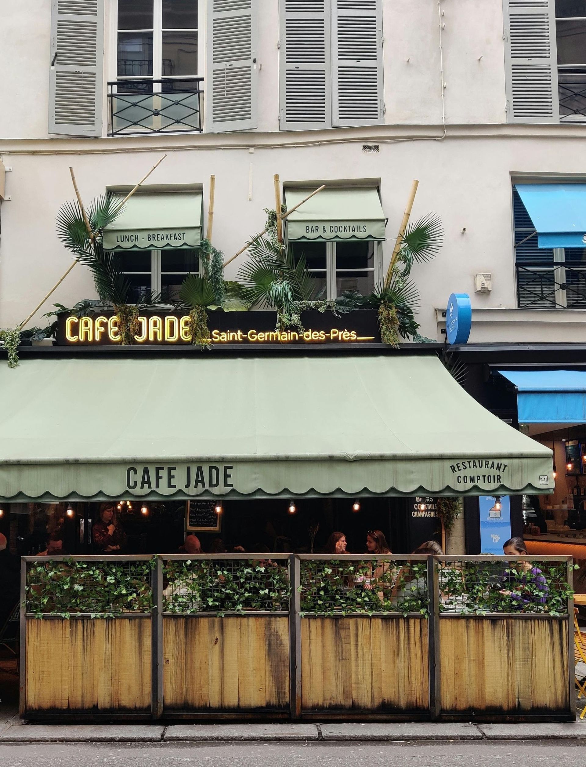 A cafe with a green awning that says cafe jade