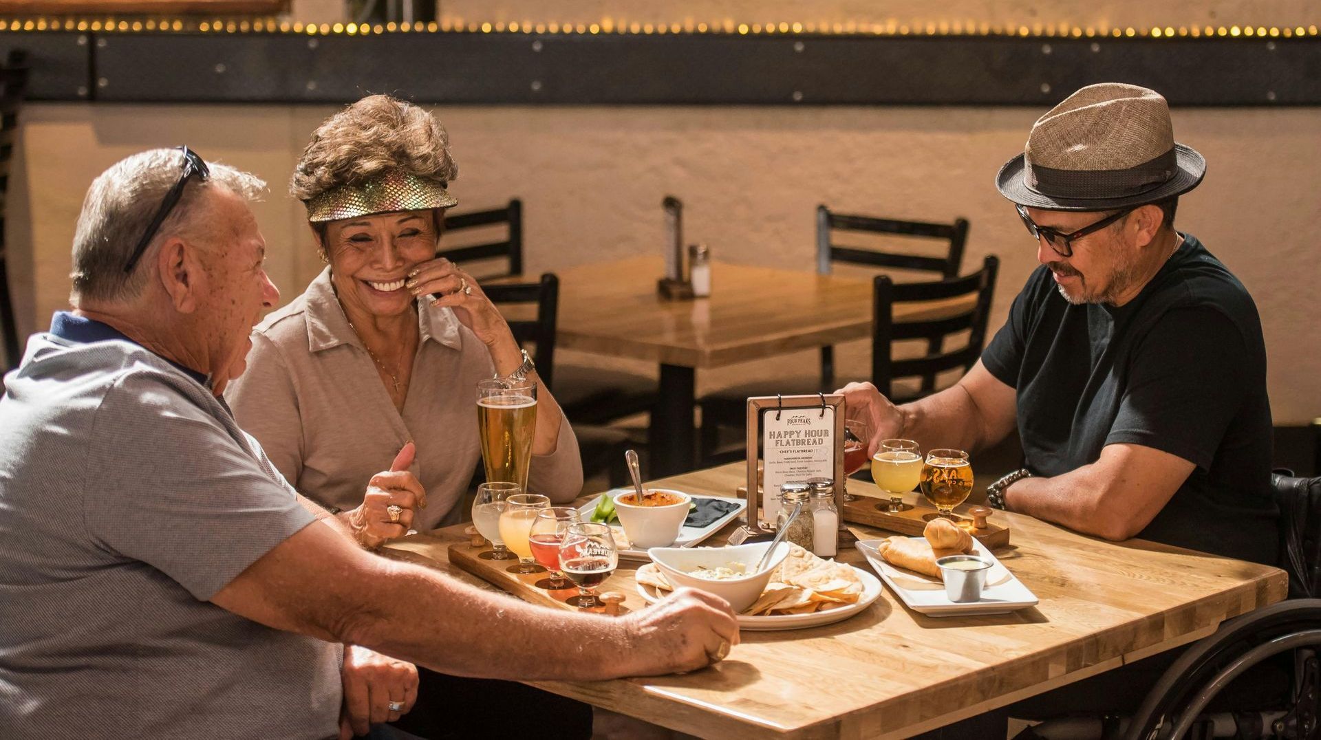 A man in a wheelchair is sitting at a table with two other people.