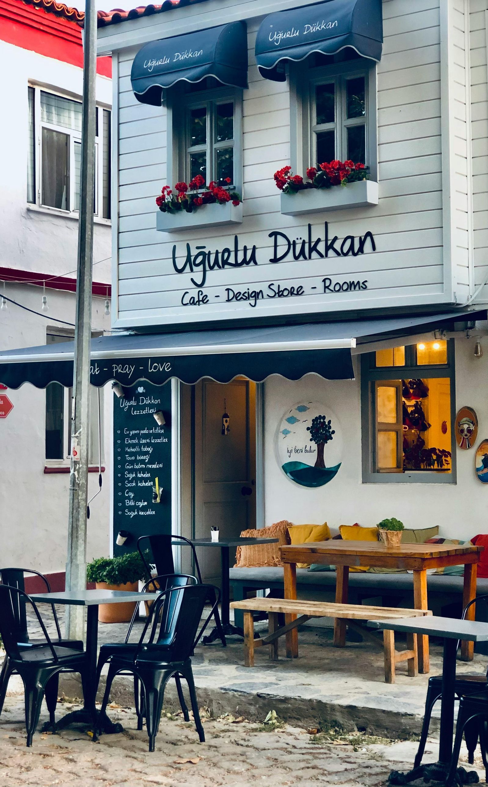 A restaurant with tables and chairs in front of it.