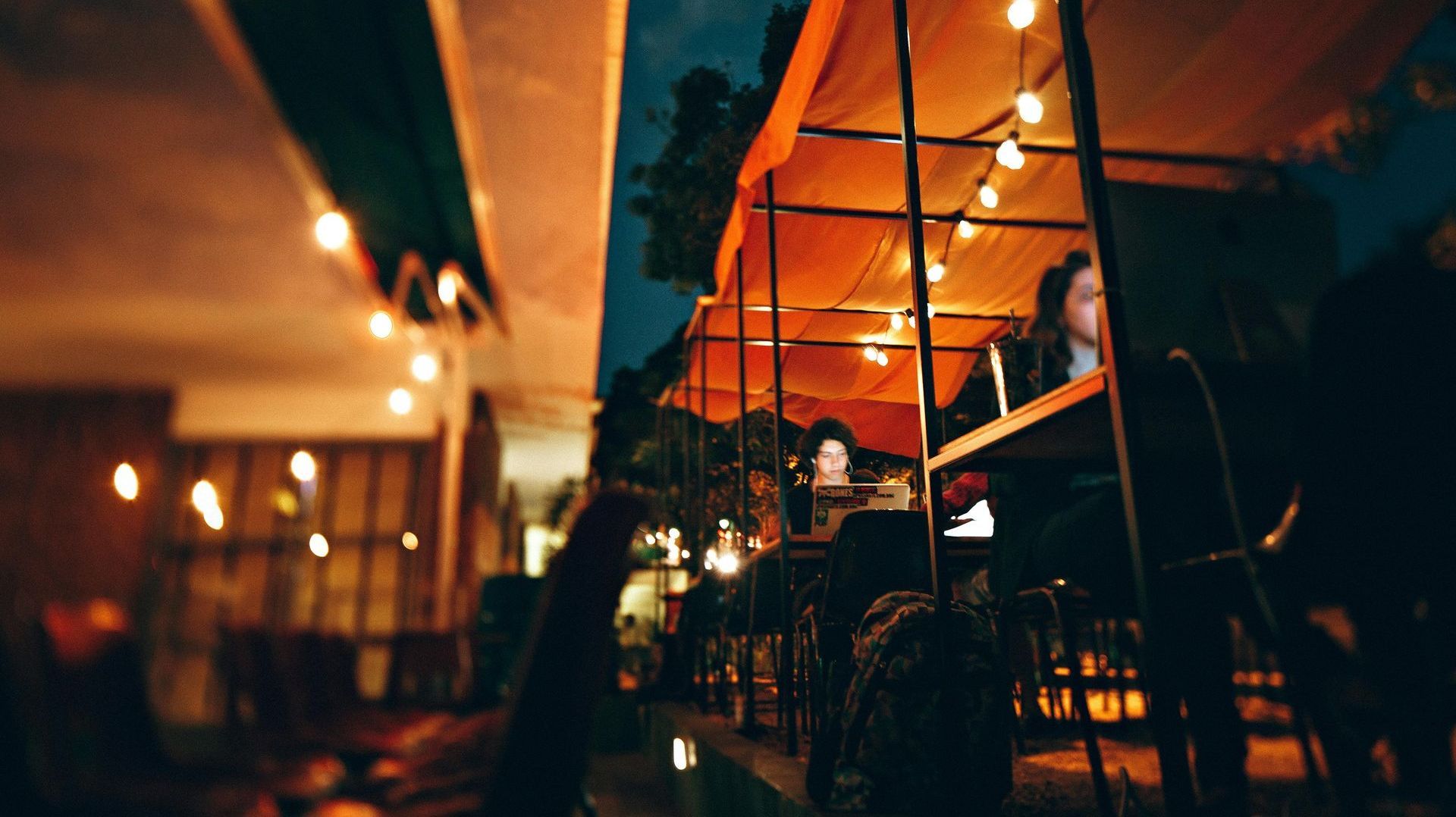 A blurry picture of people sitting at tables in a restaurant at night.