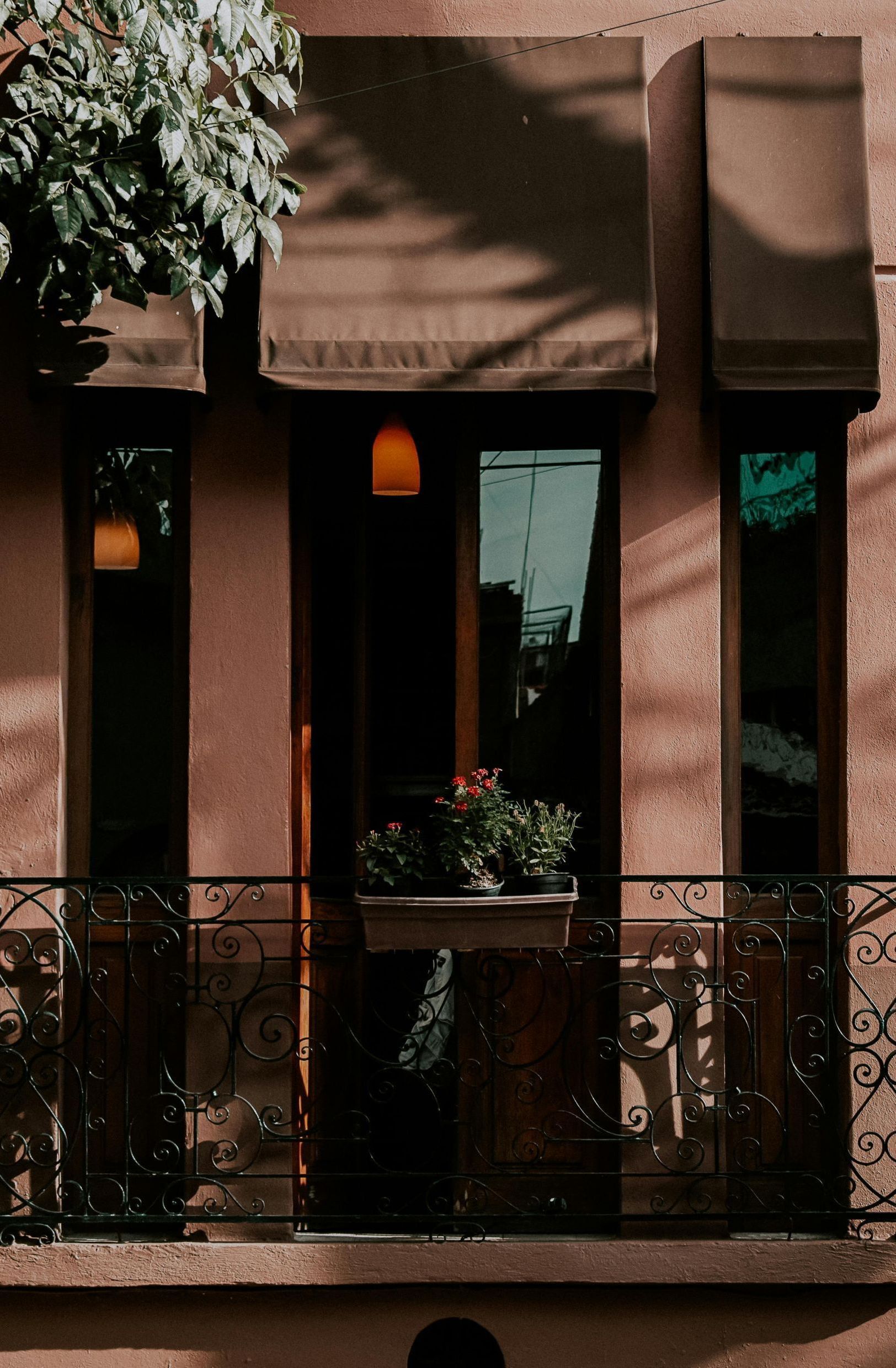 A balcony on the side of a building with a planter of flowers on it.