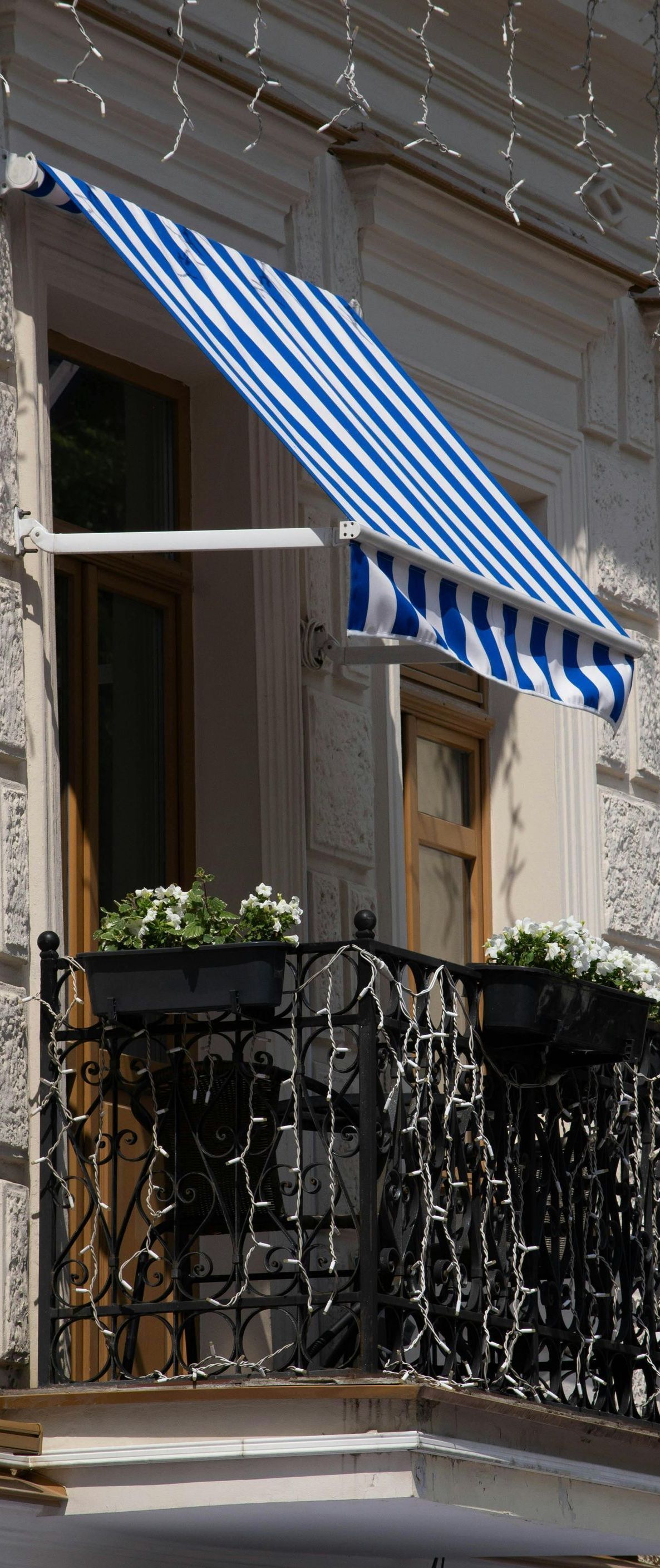 A blue and white striped awning is hanging over a balcony.