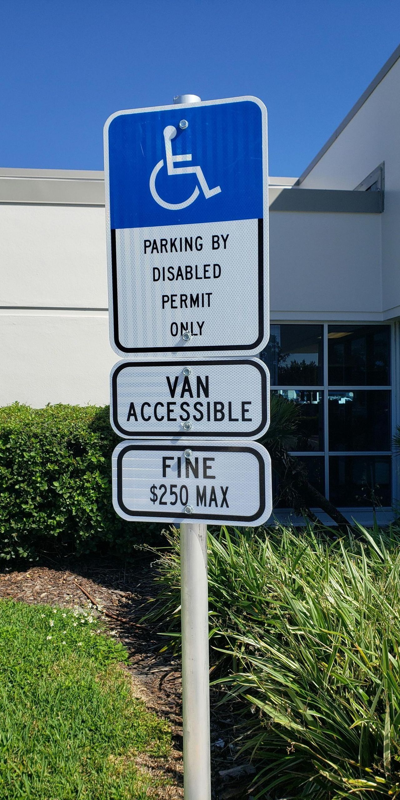 A handicapped parking sign in front of a building