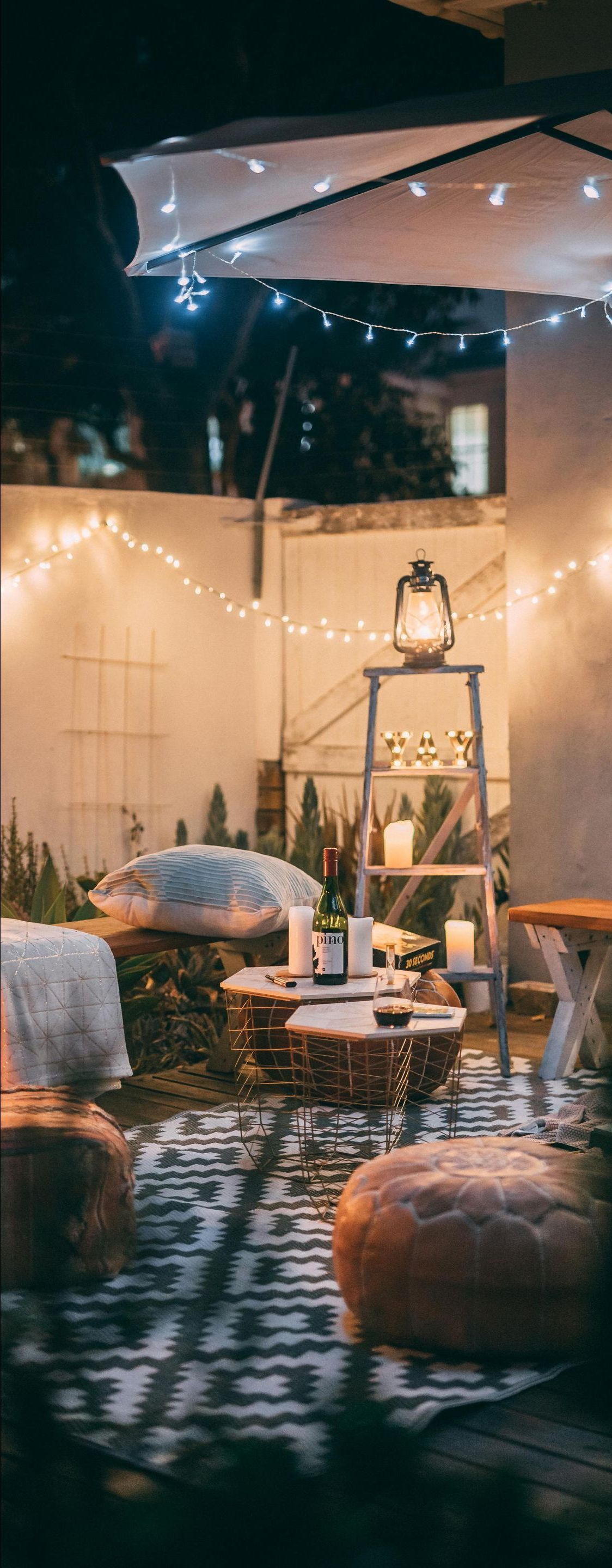 A patio with a lot of furniture and lights at night.