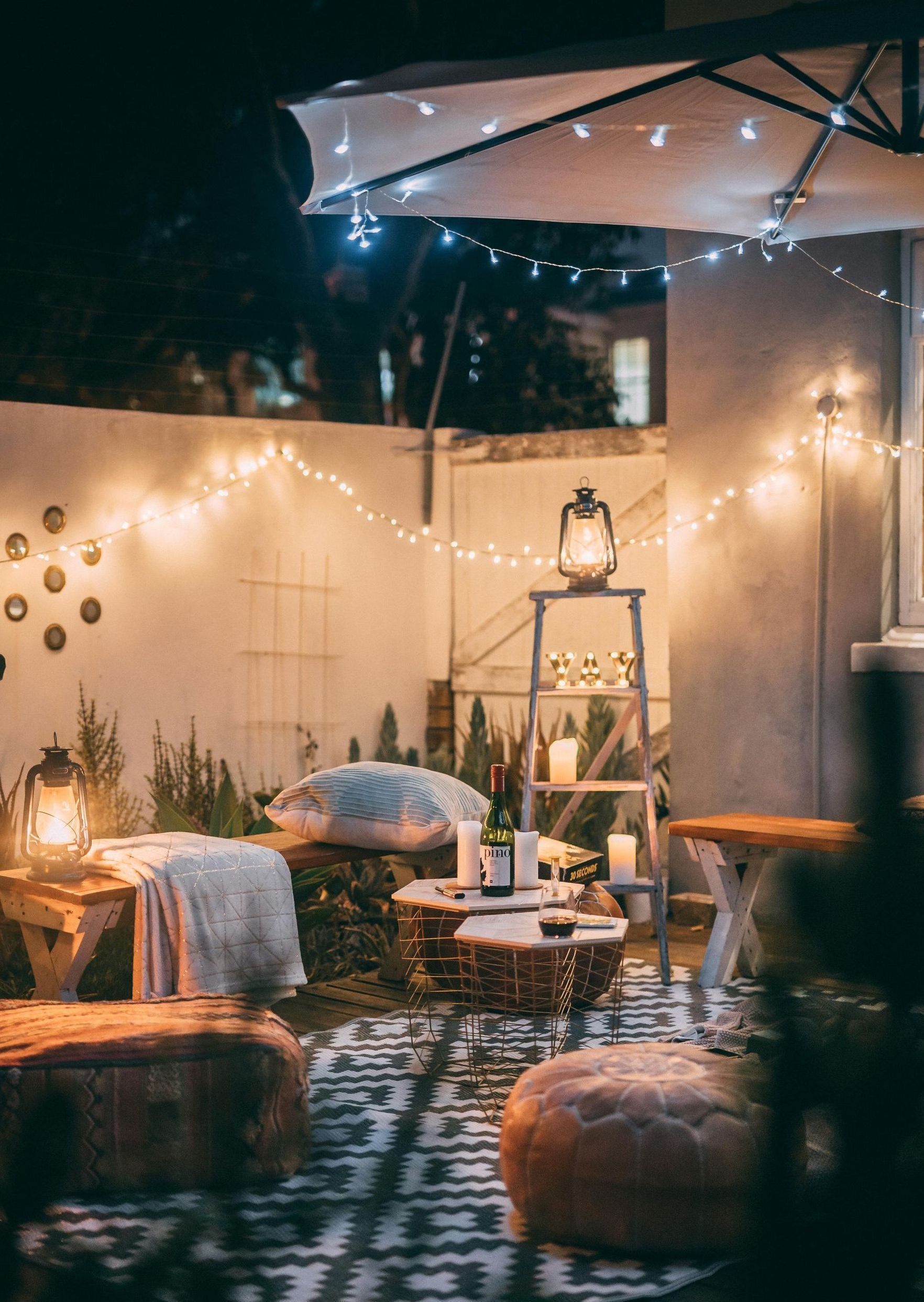 A patio with a lot of furniture and lights at night.