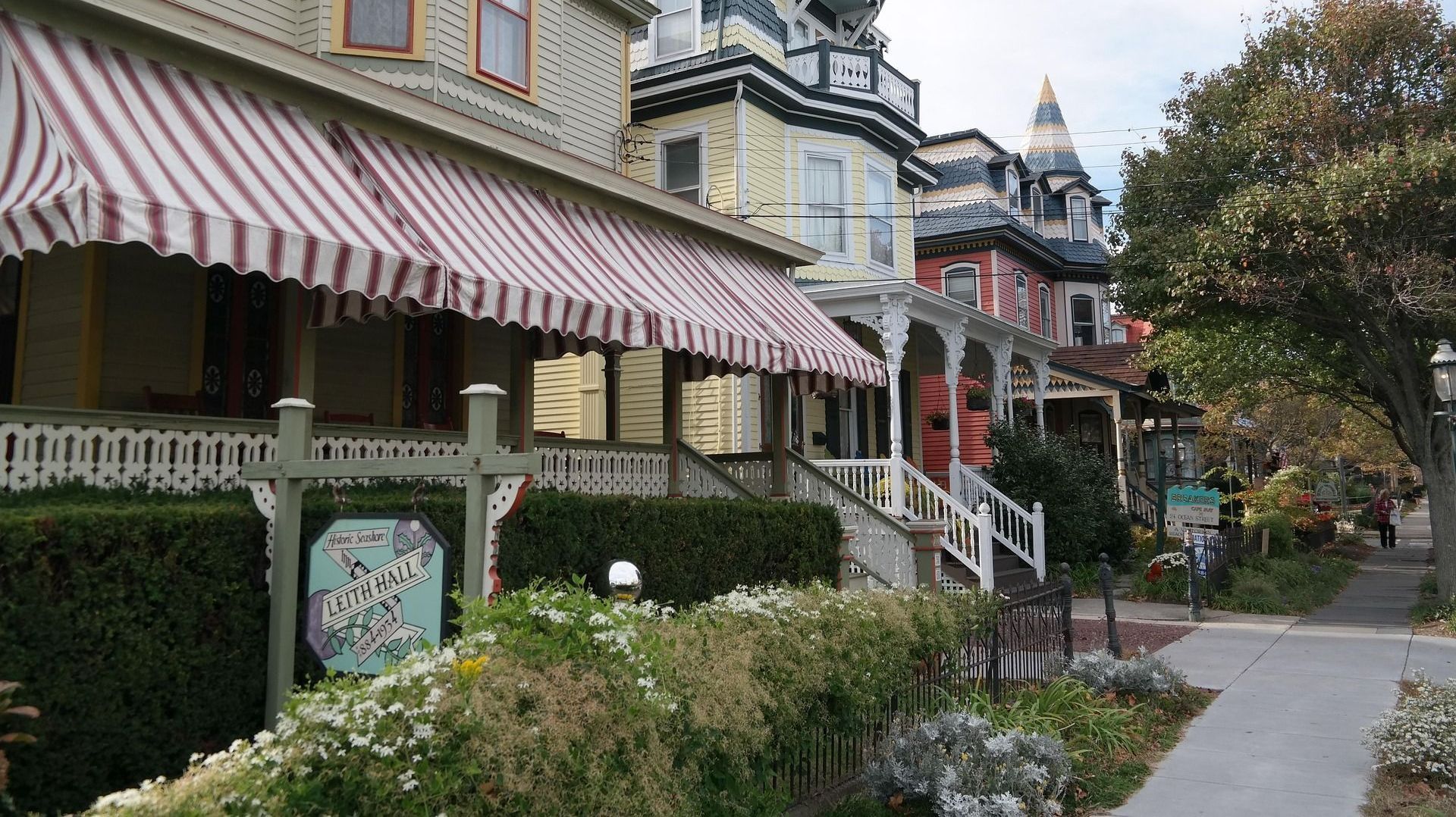 A row of houses with striped awnings on their porches