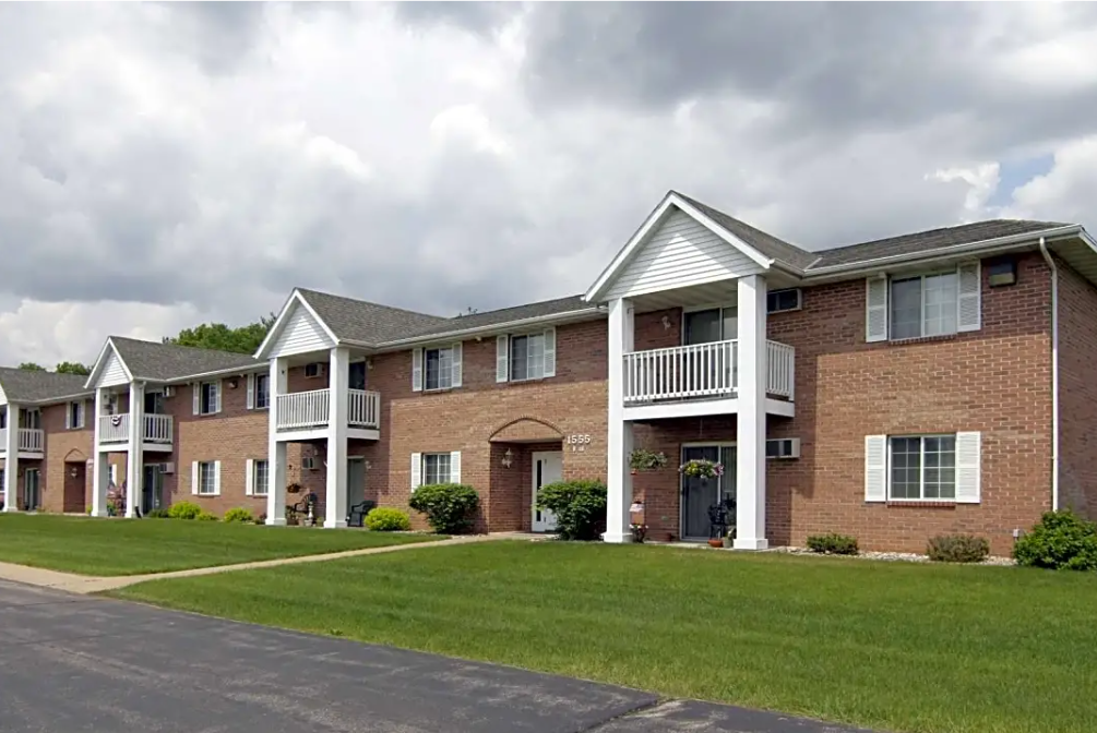 A row of brick apartment buildings with balconies on a cloudy day