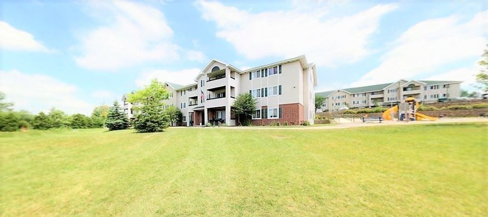 A large apartment building with a playground in front of it.