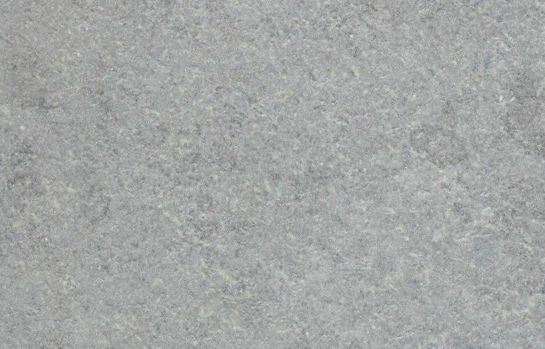 Primo piano di una superficie grigia con una consistenza granulosa.