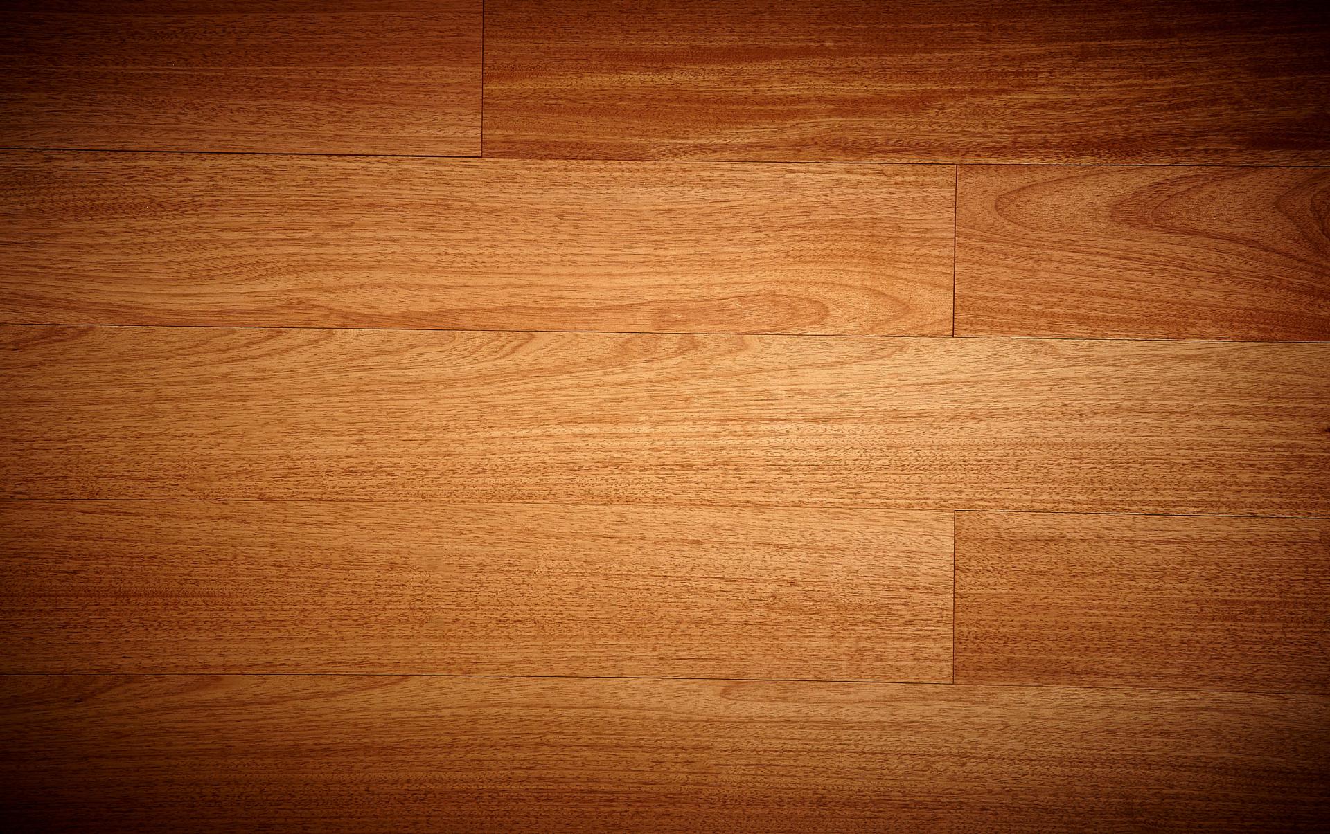 Un primo piano di un pavimento in legno con uno sfondo scuro.