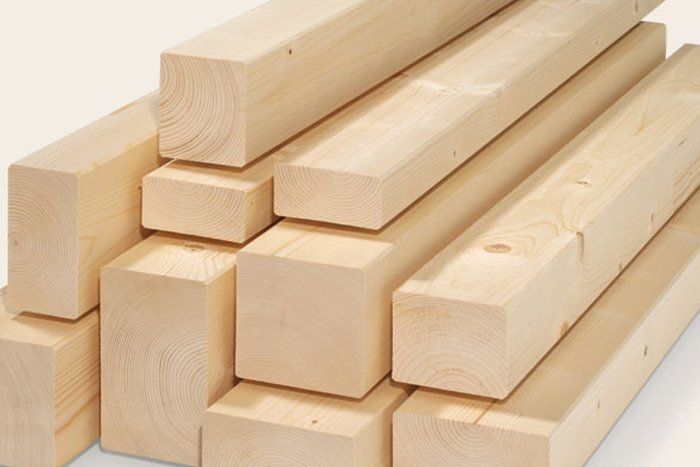 Una pila di travi di legno accatastate l'una sull'altra su una superficie bianca.