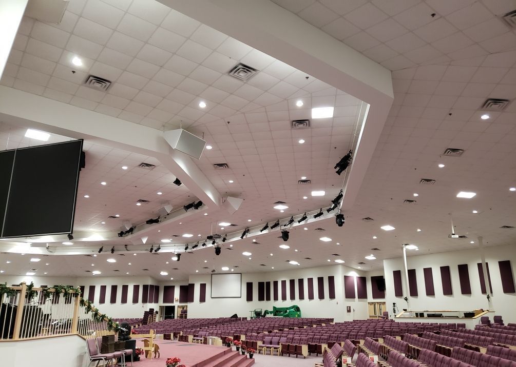 A large auditorium with purple seats and a stage