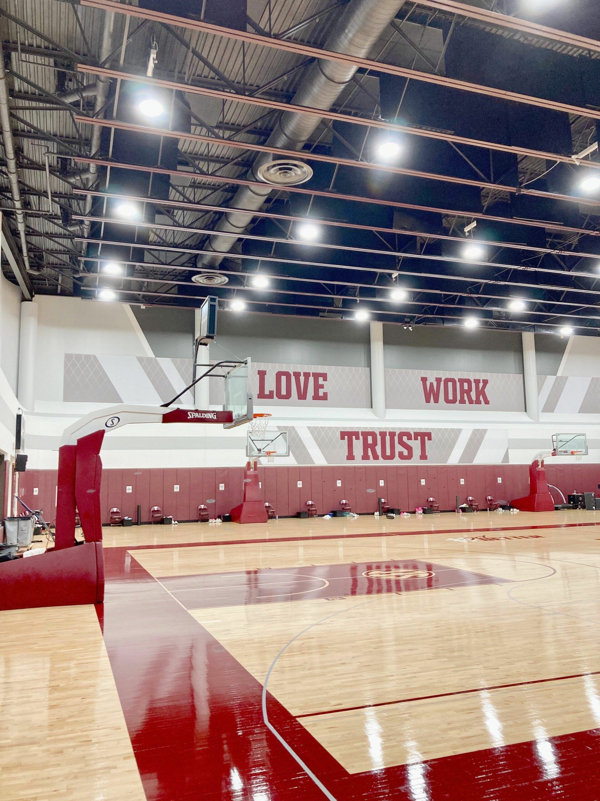 A basketball court with the words `` love work trust '' painted on the wall.