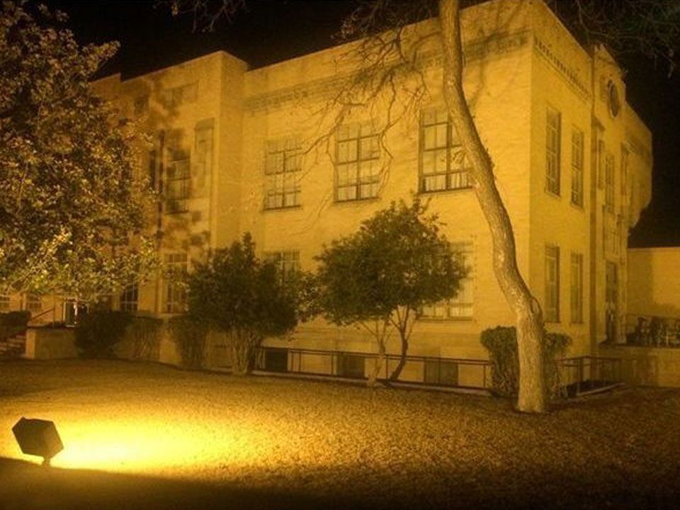 A large building with a lot of windows is lit up at night.