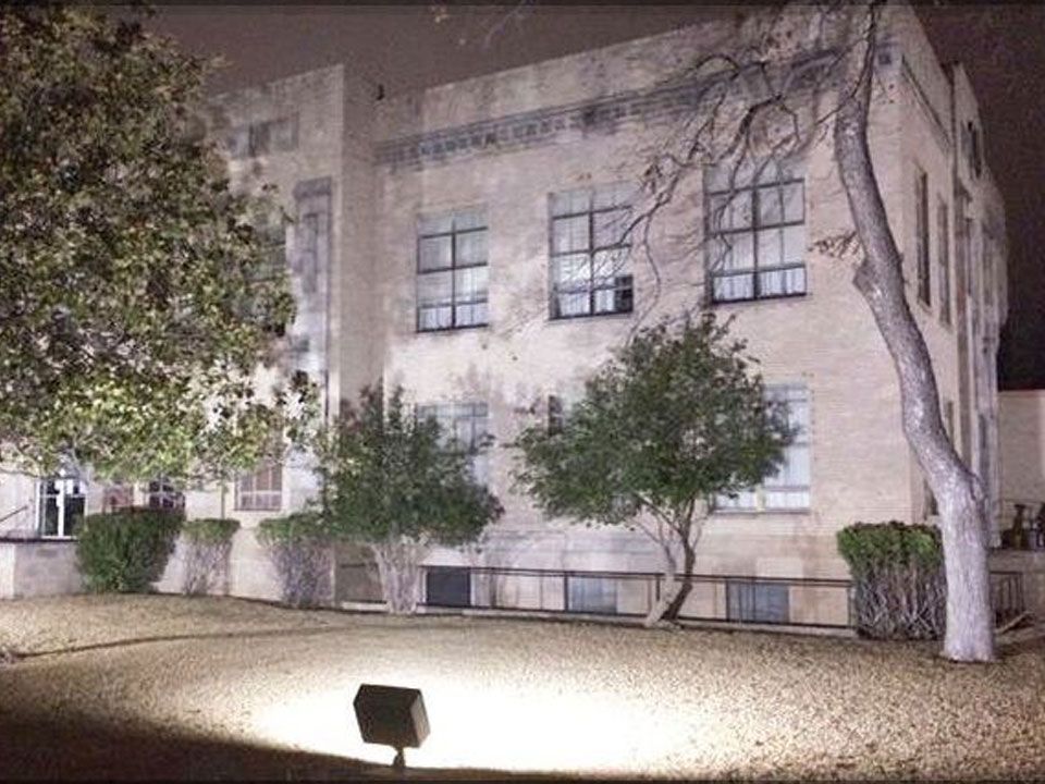 A large building with a lot of windows is lit up at night