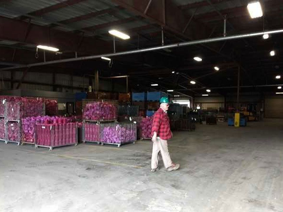 A man in a hard hat walks through a large warehouse