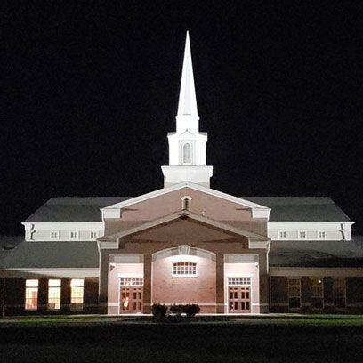 A church with a steeple lit up at night