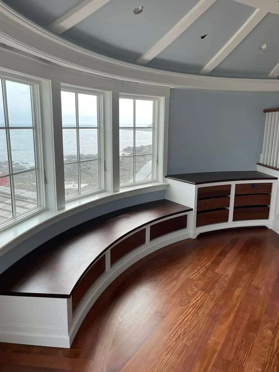 A room with a curved bench and lots of windows