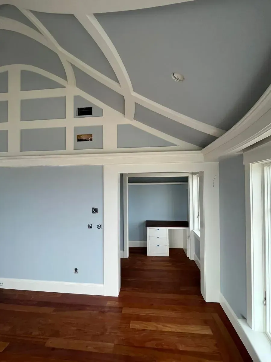 An empty room with blue walls and white trim