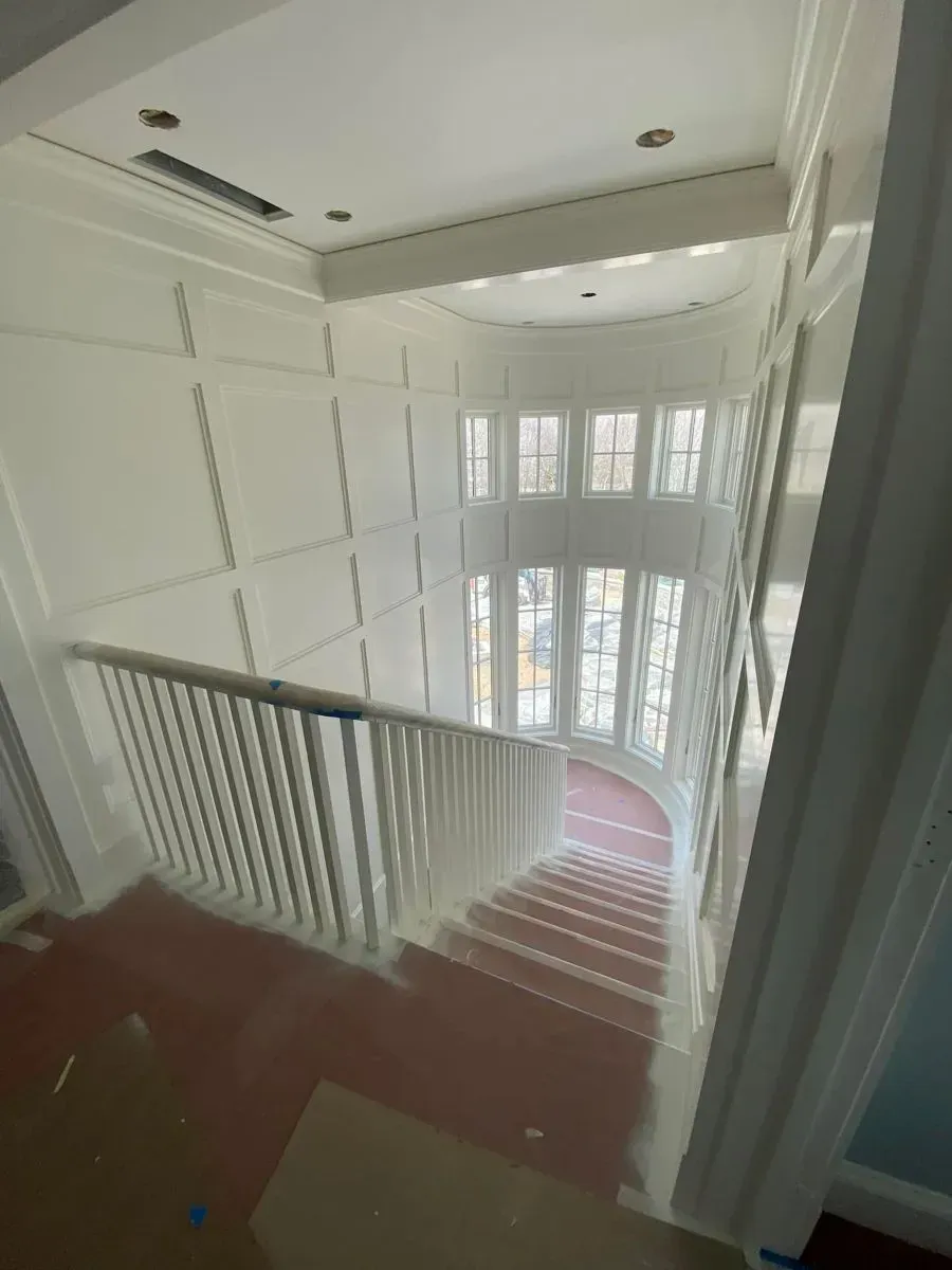 A screened in porch with chairs and a ceiling fan