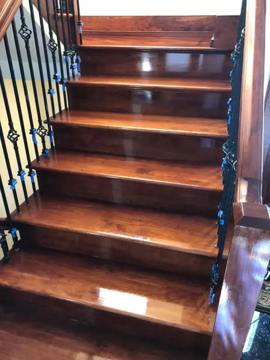 A wooden staircase with a wrought iron railing in a house.
