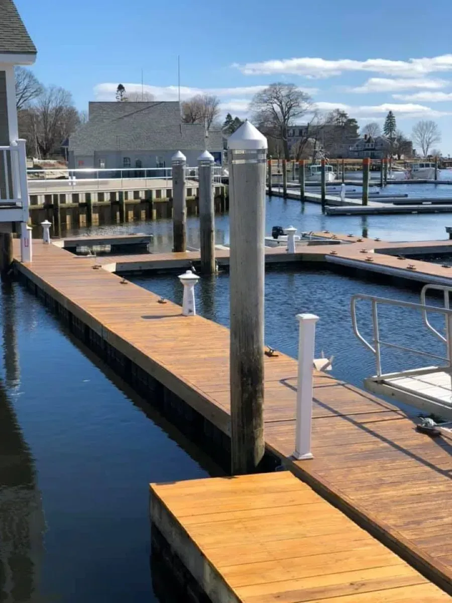 A dock in a marina with a house in the background