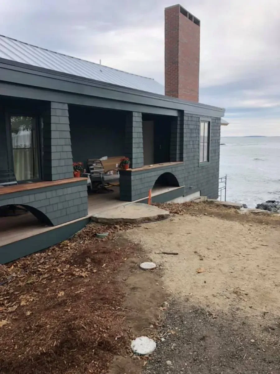 A window with a grid on it is sitting on top of a pile of gravel.